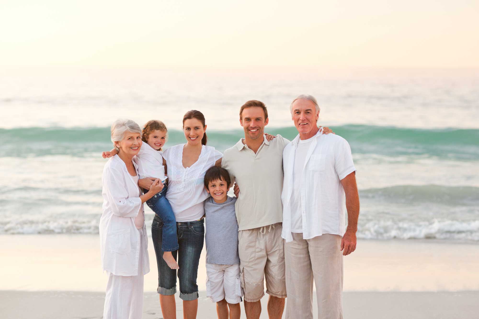 family at the beach looking joyful