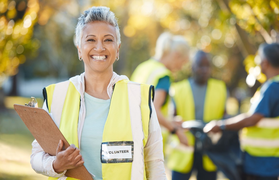 volunteering portrait and woman in park cleaning